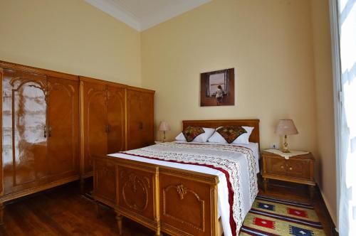 um quarto com uma cama de madeira e uma cómoda de madeira em The Place 3 charming downtown apartment no Cairo