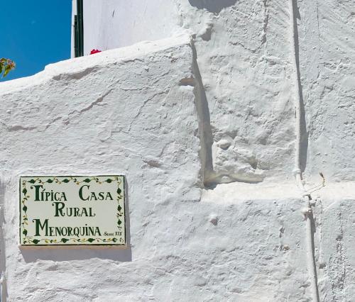 a sign on the side of a white building at Finca TONI in Alaior