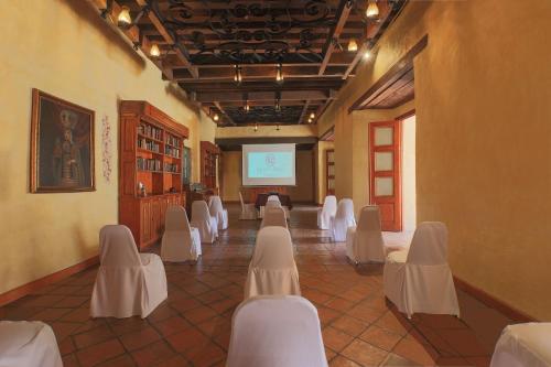 a room with white chairs and a projection screen at Quinta Real Oaxaca in Oaxaca City