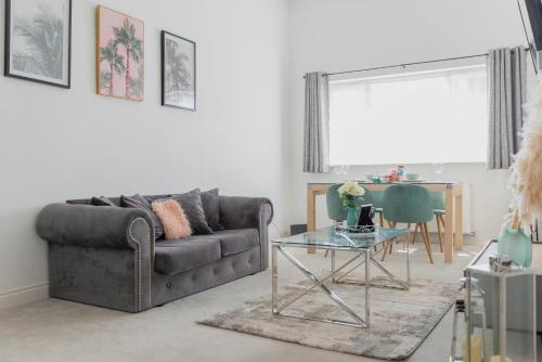 uma sala de estar com um sofá e uma mesa em Portsmouth City Centre Modern Apartment - with Free Parking em Portsmouth