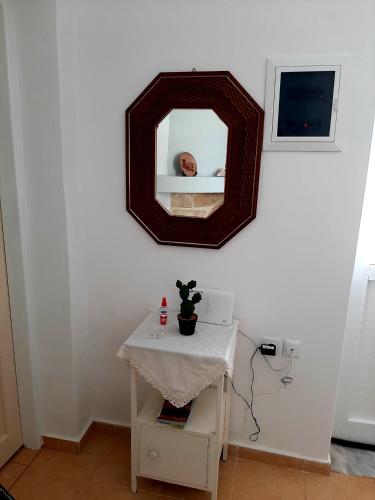a mirror on a white wall with a small table at Lemon Garden 2 in Karídhion