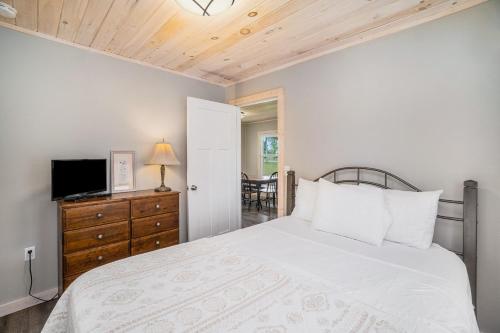 Schlafzimmer mit einem Bett und einer Kommode mit einem TV in der Unterkunft Northwood Nest in Arcadia