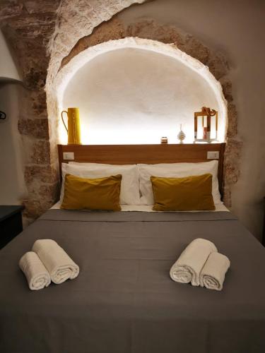 una camera da letto con un letto con due asciugamani sopra di A Petre Luxury Room a Cisternino
