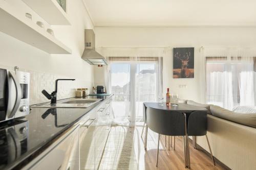 a kitchen with a counter and a table in a room at Avenida & Mercado by Home Sweet Home Aveiro in Aveiro