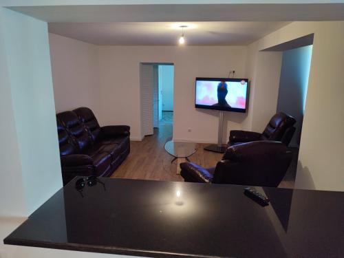 uma sala de estar com mobiliário de couro e uma televisão de ecrã plano em Luca apartament 3 camere em Băile Herculane