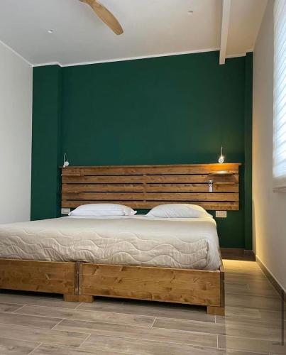 a bedroom with a large bed with a green wall at Why Not B&B in San Polo Matese
