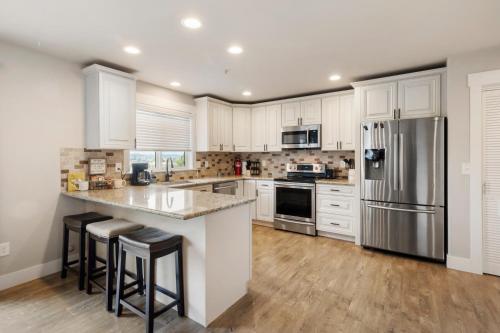 a kitchen with white cabinets and a stainless steel refrigerator at HoneyHomes Spectacular View Home with Amenities in Sumner