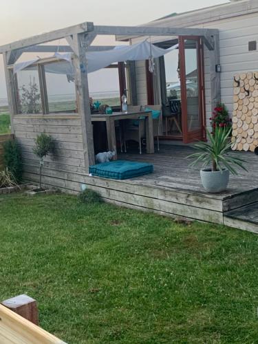 a deck with a table and an umbrella at Chalet Meerblick Wattenmeer in Westerland