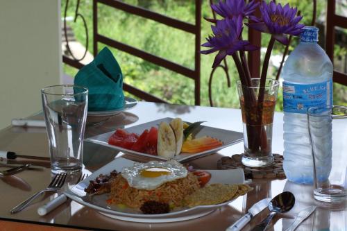 a table with a plate of food on a table at Nature Walk Resort in Kandy