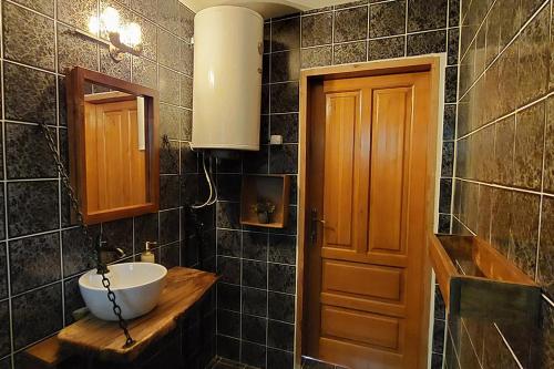 a bathroom with a sink and a wooden door at Villa Ramonda in Dolna Matka