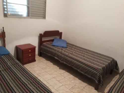 a bedroom with two beds and a nightstand with a blue bag at Casa em Olímpia in Olímpia