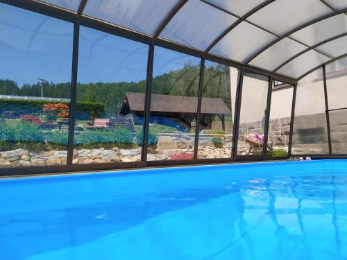 a swimming pool with a view of a garden and a house at Ubytování Na Kovárně in Smržovka