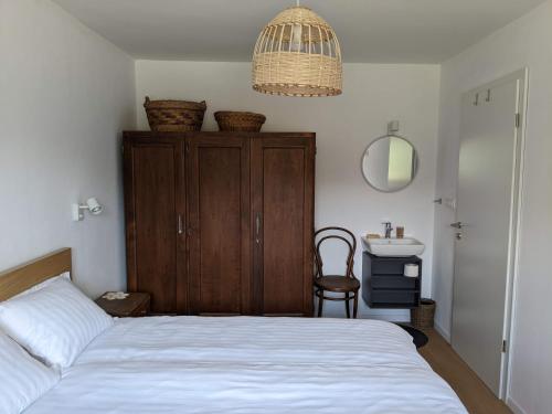 1 dormitorio con 1 cama, armario y silla en Klančarjeva domačija - Spacious countryside apartment on an eco farm, 