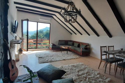 a living room with a couch and a table with a guitar at Villa Ramonda in Dolna Matka