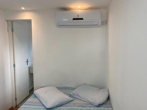 a small room with a bed with two pillows at Loft container central c/ estacionamento in Pelotas