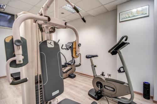 a gym with treadmills and elliptical machines at Hotel Della Rotonda in Saronno