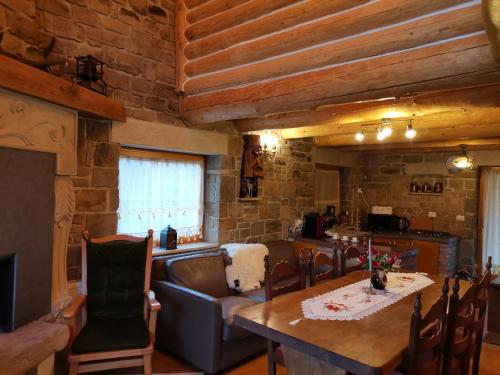 a kitchen and dining room with a table and chairs at Cabana Casa de Piatra, de la Mara in Deseşti