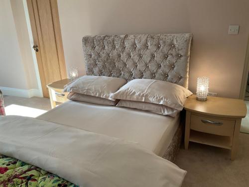 a bedroom with two beds and a headboard and a table at The Gables in Haworth