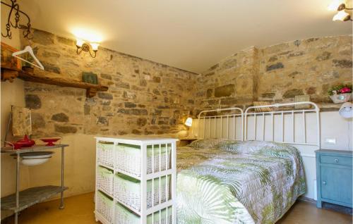 a bedroom with a bed and a stone wall at 1 Bedroom Gorgeous Apartment In Villagrande Di Monteco 