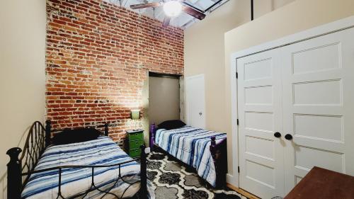 1 dormitorio con 2 camas y pared de ladrillo en Family-Friendly 3 bedroom in Historic building!, en Lynchburg