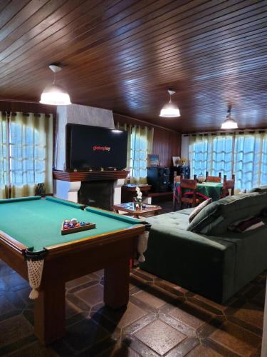 a living room with a pool table and a tv at Pousada Village Pôr do Sol in Campos do Jordão