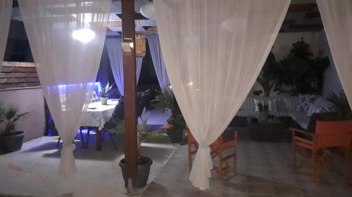 a room with white drapes and a dining room with a table at Modern Villa in Chania in Perivólia