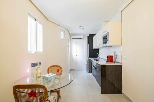 a small kitchen with a glass table in a room at Cuidadosamente decorado apartamento junto al metro in Madrid