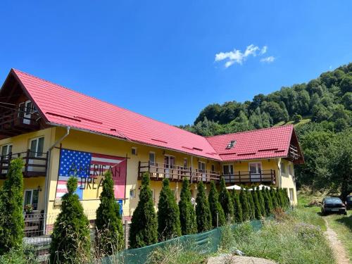 a building with a red roof and a bunch of trees at American Dream in Şimon