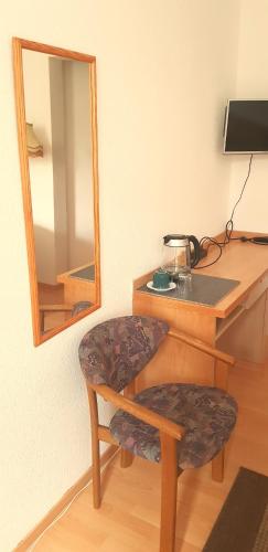a desk with a mirror and a stool in a room at Villa Hoffnung in Bad Elster