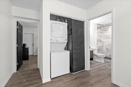 a bathroom with a white refrigerator and a toilet at Travel Inn of Titusville in Titusville