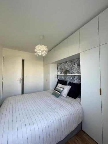 a bedroom with a large bed with white walls at Capsule Océan, à moins de 10 min de la plage in Aytré