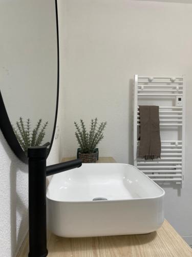 une baignoire blanche assise sur une table avec un miroir dans l'établissement Capsule Océan, à moins de 10 min de la plage, à Aytré