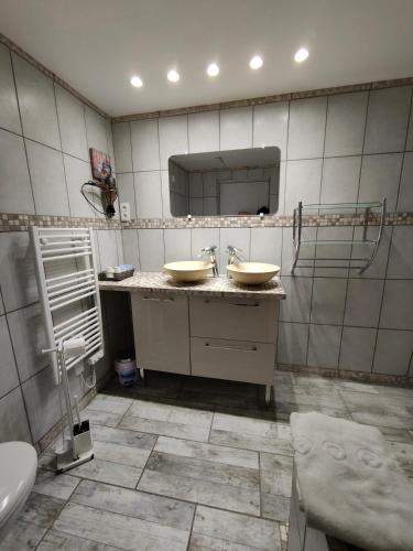 a bathroom with two sinks and a mirror at Auberge Le Chata in Saint-Georges-de-Didonne