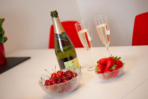 a bottle of champagne and two glasses of strawberries at Bymarkens B&B in Roskilde