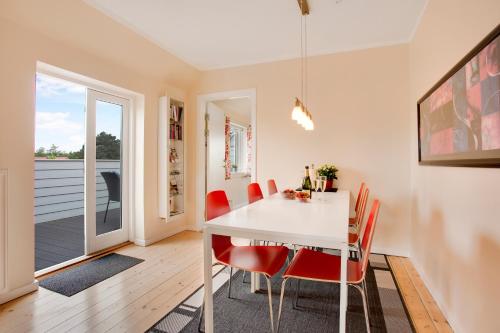a dining room with a white table and red chairs at Bymarkens B&B in Roskilde