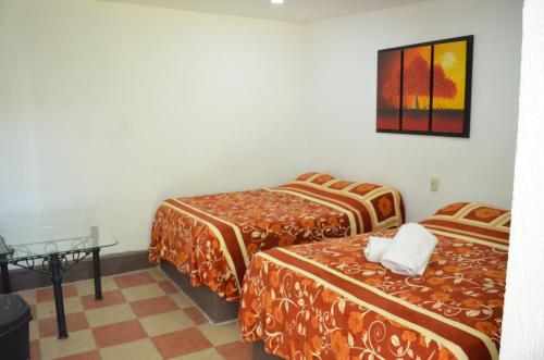 a hotel room with two beds and a table at Vicalis Hotel, Villas y Glamping in San Sebastian Xolalpa