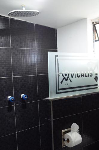 a bathroom with a shower with a sign on the wall at Vicalis Hotel, Villas y Glamping in San Sebastian Xolalpa