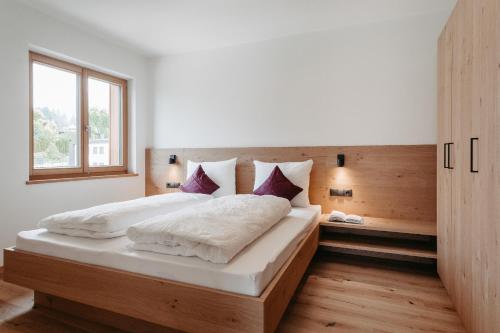 a bedroom with a large bed and a window at Torgglbauer Apartment 3 in Merano