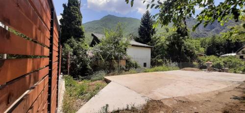 a house with a brick wall next to a driveway at Villa Ramonda in Dolna Matka