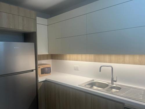 cocina con fregadero y nevera en Luxury privet 3 bed room 1 saloon security Nearby vadi istanbul 10min to mall of Istanbul and city centre private spa & winter pool for women, en Estambul