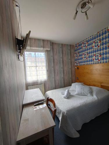 a bedroom with a bed and a table and a window at Auberge Le Chata in Saint-Georges-de-Didonne
