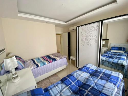 um pequeno quarto com 2 camas e um espelho em Modern 2bedroom apt on Cleopatra (WiFi,pool) em Alanya