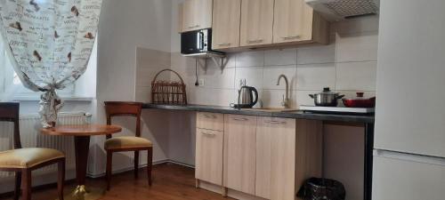 a kitchen with wooden cabinets and a counter top at Lorf Hostel&Apartments in Krakow