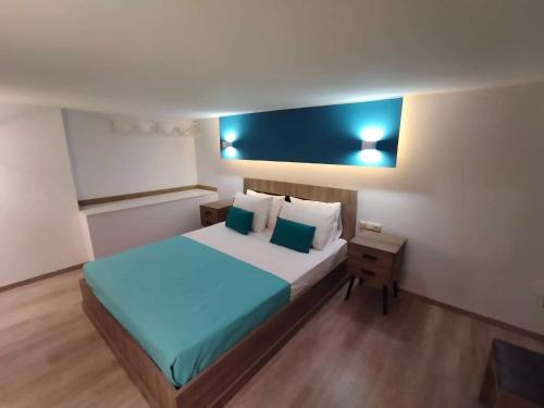 a bedroom with a large bed with blue sheets and pillows at Plumbago Apartment in Theológos