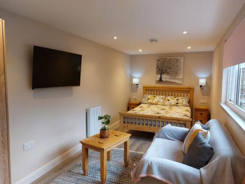um quarto com uma cama, um sofá e uma televisão em Southwell Home Stay em Southwell
