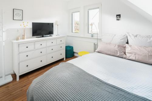 a bedroom with a bed and a dresser with a tv at Stewohood Norderney in Norderney