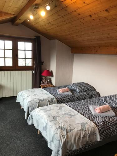 a row of beds in a room with wooden ceilings at Chalet LA TOUPINE centre St Gervais in Saint-Gervais-les-Bains
