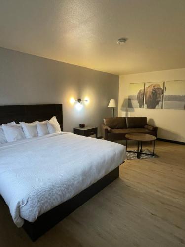 a hotel room with a large bed and a couch at The Scout INN in Cody