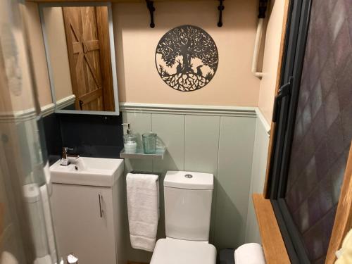 a small bathroom with a toilet and a sink at Brook the Shepherd Hut in Saltash