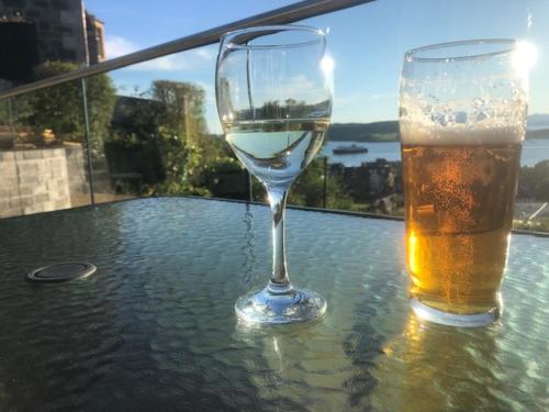 a glass of wine and a glass of beer on a table at Benvoulin Bothy - luxury pod with stunning views in Oban